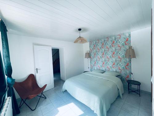 une chambre avec un lit et une chaise dans l'établissement Le gîte de barville, à Montfarville