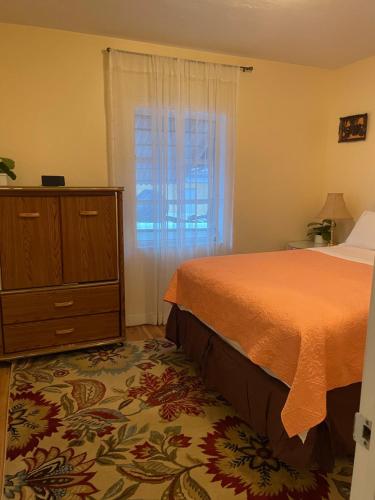 a bedroom with a bed and a dresser and a window at House next to the golf course in Plantation