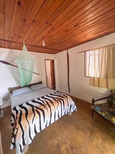 a bedroom with a zebra print bed in a room at Pousada Roy Bonete in Ilhabela
