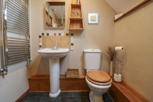a bathroom with a toilet and a sink at Post House in Holsworthy