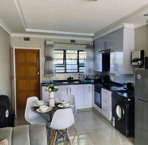 a kitchen with a table and chairs in a kitchen at Beautiful 3-Bed House in Harare in Harare