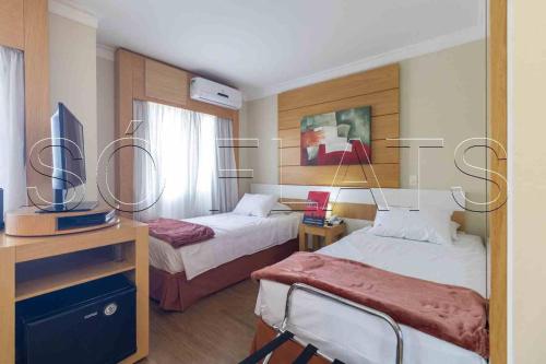 a hotel room with two beds and a tv at Flat Nobile Congonhas in Sao Paulo