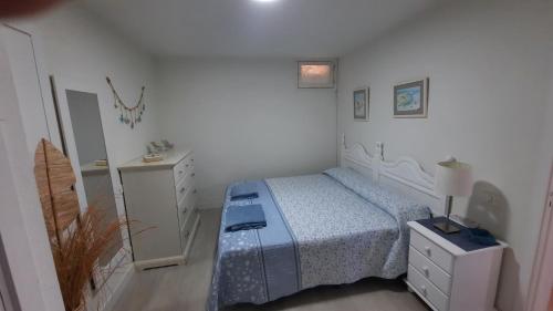 - une chambre avec un lit, une commode et un miroir dans l'établissement APARTAMENTOS BUNGAMERICA n114, à Playa de las Americas