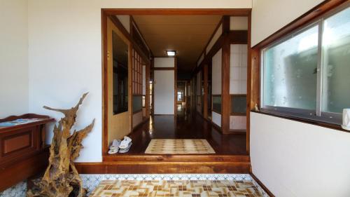 a hallway of a house with a door and a window at 一棟貸し 喜瀬しーばなゲストハウス -Traditional House Rent- in Amami