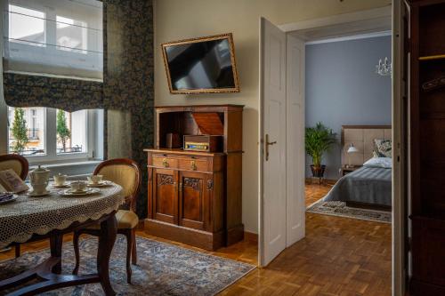 ein Wohnzimmer mit einem Tisch und ein Schlafzimmer in der Unterkunft Apartamenty na Starówce in Kalisz