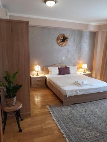 um quarto com uma cama grande e 2 mesas e 2 candeeiros em Ap Hector em Mamaia Nord – Năvodari