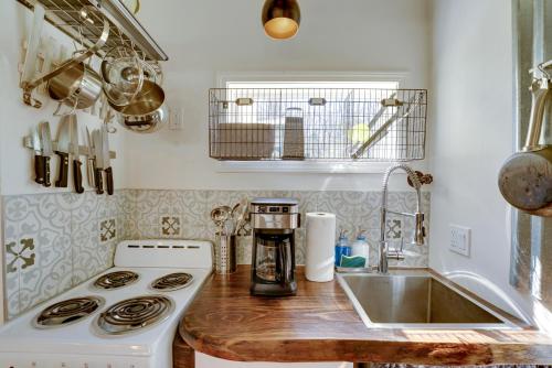 uma cozinha com um fogão branco e um lavatório em 4-Season Gold Coast Cottage, 2 Mi to Winter Sports em Muskegon