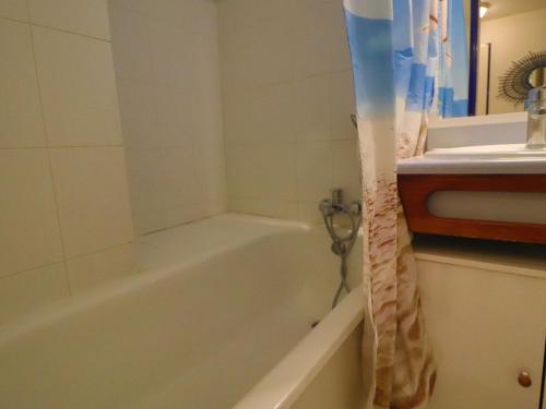 une salle de bain avec une baignoire et un lavabo dans l'établissement Joli T2 cabine avec terrasse face mer, parking, ascenseur, pour 5 pers - FR-1-472A-297, à Sète