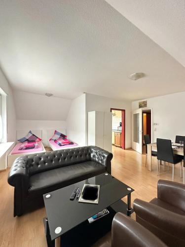 a living room with a black leather couch and a table at Holiday Apartment Adenau in Adenau