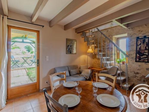 un salon avec une table et des chaises en bois dans l'établissement Gîte rustique avec 2 chambres, nature, animaux admis, wifi et parking - FR-1-622-78, à Vihiers