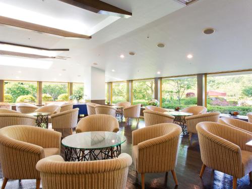 a restaurant with chairs and tables and windows at Hotel Green Plaza Hakone in Hakone