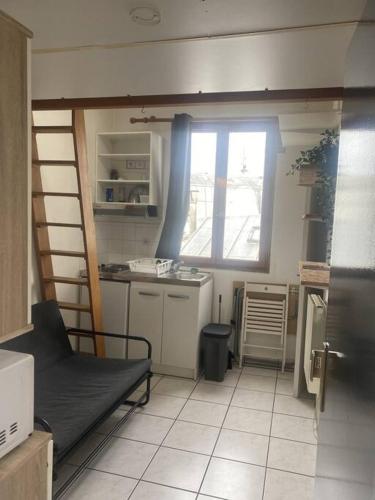 Il comprend une petite cuisine avec un lit et une fenêtre. dans l'établissement Studio Sacré-Cœur - Chappe, à Paris