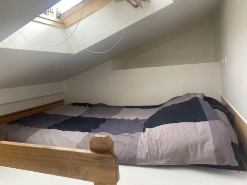 une chambre avec un lit dans un grenier dans l'établissement Studio Sacré-Cœur - Chappe, à Paris