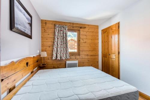 ein Schlafzimmer mit einem Bett und einem Fenster in der Unterkunft Résidence Les Fermes du Soleil - maeva Home - Appartement 3 Pièces 6 Personnes - Sélection MAE-1535 in Les Carroz d'Araches