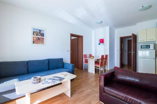 a living room with a blue couch and a table at Todorka Apartments in Bansko in Bansko