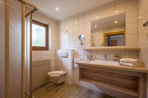 uma casa de banho com um lavatório, um WC e um espelho. em Haus Kirchmaier em Pertisau