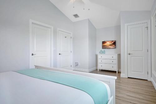 a white bedroom with a bed and a dresser at Isla Key Lime - Waterfront Boutique Resort, Htd Pool, Dock, Walkable in Islamorada