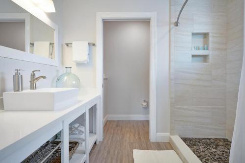 a white bathroom with a sink and a shower at Isla Key Lime - Waterfront Boutique Resort, Htd Pool, Dock, Walkable in Islamorada