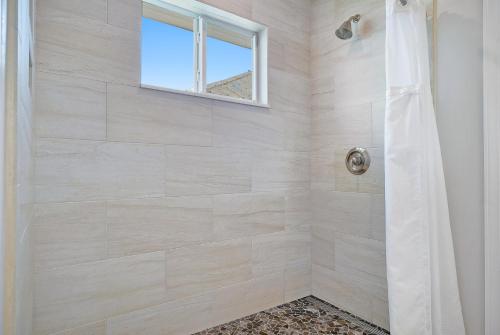 a bathroom with a shower with a window at Isla Key Lime - Waterfront Boutique Resort, Htd Pool, Dock, Walkable in Islamorada