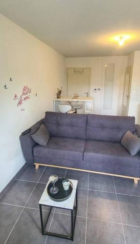 un soggiorno con divano blu e tavolo di Grand Studio proche Montpellier a Castelnau-le-Lez