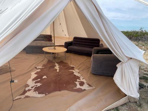 a tent with couches and a table and a rug at New Yurt City in Lake Los Angeles