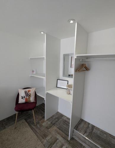 Cette chambre blanche dispose d'un bureau et d'une chaise. dans l'établissement Appartement 100m2, indépendant dans notre maison, à Garennes-sur-Eure