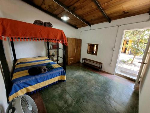 een slaapkamer met een bed in een kamer met een ventilator bij Casa TranSierra in Oaxaca City
