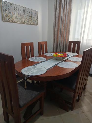 a wooden table with a bowl of fruit on it at Rina Crystal Accommodation in Mombasa
