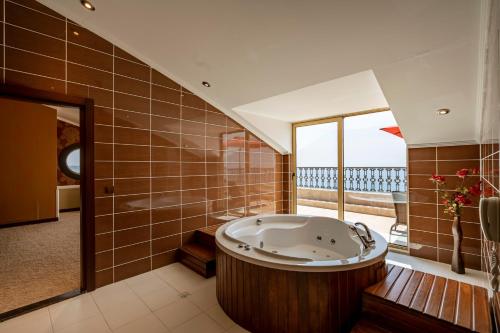 a large bathroom with a tub and a large window at Megasaray Westbeach Antalya in Antalya