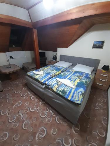 a bedroom with a bed with a blue comforter at Penzion Krušnohorka in Tatrovice