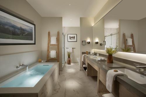 ein Badezimmer mit einer großen Badewanne und einem großen Spiegel in der Unterkunft Stilwell Hotel in Carmel