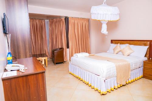 a bedroom with a bed and a desk with a telephone at Paleo Hotel and Spa in Thika