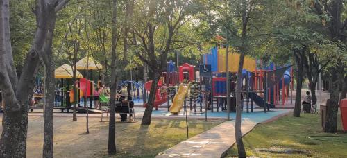 einen Spielplatz in einem Park mit Rutsche in der Unterkunft Departamento en Puebla (en torre Artema- zona Angelópolis) in Puebla