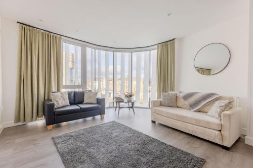 a living room with a couch and a chair at Vertigo Boutique Sleeps 4 London in Kingston upon Thames
