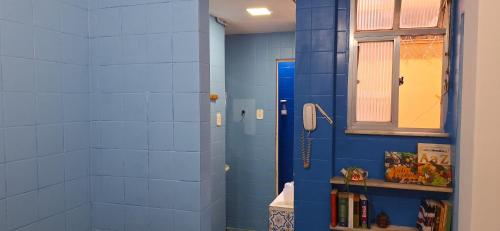 baño con ducha de azulejos azules y ventana en Leblon beach, en Río de Janeiro