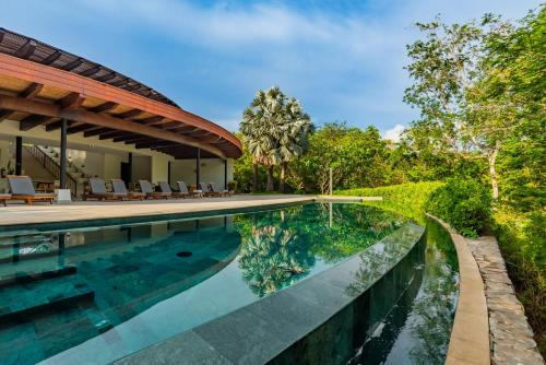 una imagen de una piscina al lado de una casa en Carao T2-6 Luxury Penthouse Adults Only - Reserva Conchal, en Brasilito