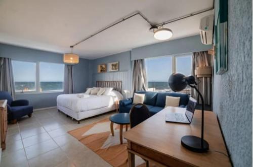 a bedroom with a bed and a desk with a laptop at ZAG Coliving Punta del este in Punta del Este