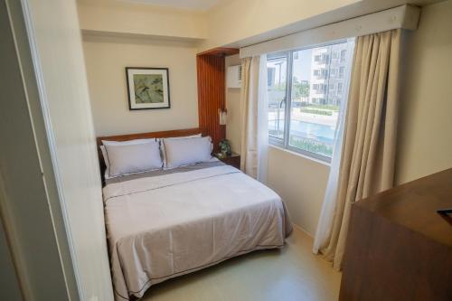 - une chambre avec un lit et une grande fenêtre dans l'établissement 1Bedroom Condo Unit, à Iloilo