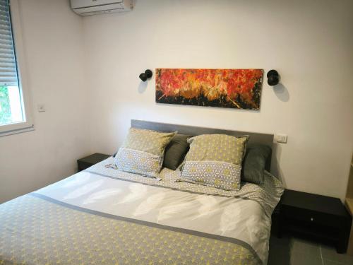 a bed in a bedroom with a painting on the wall at Appartement Fréjus in Fréjus