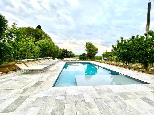 a swimming pool with a row of benches around it at Tenuta EnGi in Verona