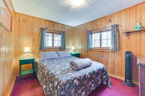 um quarto com uma cama e duas mesas e duas janelas em Roscommon Cabin Less Than Half-Mi to Higgins Lake! em Roscommon