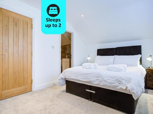 1 dormitorio con 1 cama grande y puerta de madera en Spacious Upstairs Bedroom Ensuite with Free Parking - Room 4, en Brentwood
