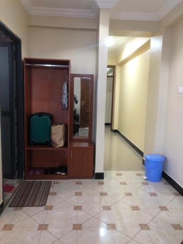 a room with a hallway with a cabinet and a floor at Mbazi Hotel in Tanga