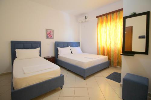 um quarto de hotel com duas camas e um espelho em Lengu Holidays Houses em Saranda