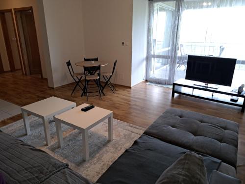 a living room with a couch and tables and a tv at Apartmán Zuzu FREE Parking in Trenčín