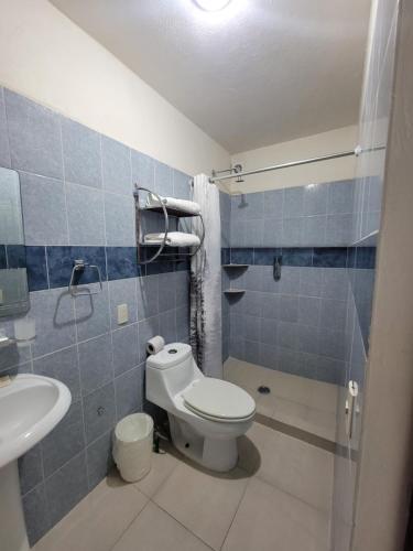 a bathroom with a toilet and a sink at Hotel Paraiso Inn in Tehuacán