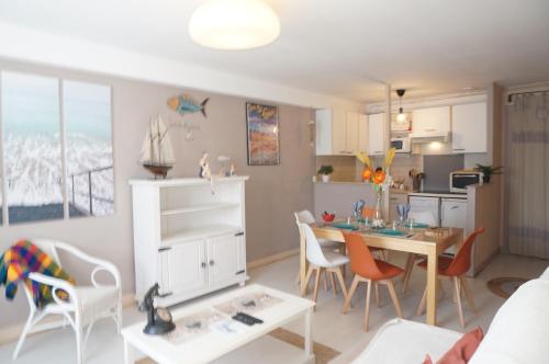 une cuisine et une salle à manger avec une table et des chaises dans l'établissement Le 33 Cour Normande - Appartement 2 chambres - 2 à 4 personnes - coeur Cabourg, à Cabourg