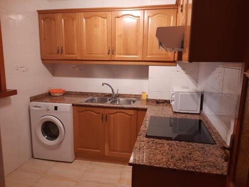 a kitchen with a sink and a washing machine at Calpe Perlamar in Calpe