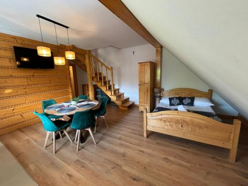 a bedroom with a bed and a table and chairs at Apartamenty Borysek De Lux in Białka Tatrzanska