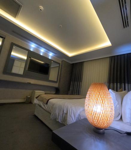 a hotel room with a bed and a lamp on a table at Mariana Hotel Erbil in Erbil